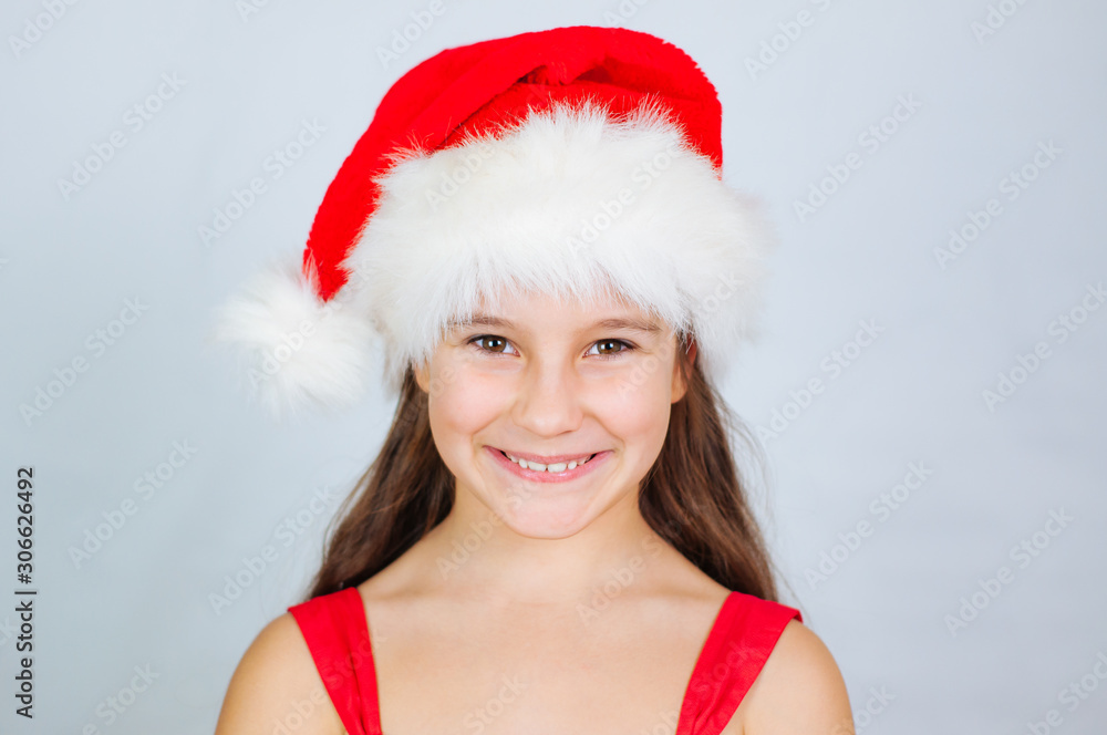 Little cute girl smiles in a santa hat Little cute girl smiles in a santa hat