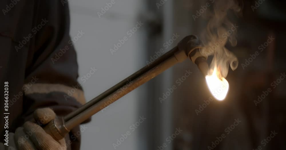 Worker lights a welding torch creating a giant flame Worker lights a welding torch creating a giant flame
