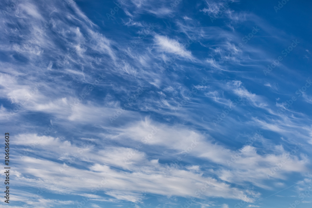 Beautiful cirrus clouds on a blue autumn sky in a frosty day. Sky pattern.	