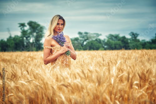 Young romantic woman on a walk in a wheat field
