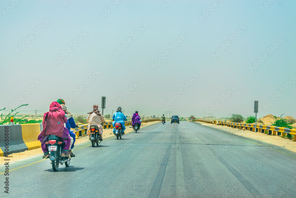 Obraz premium villager are taking their families on the bikes without helmets on a fast speed highway