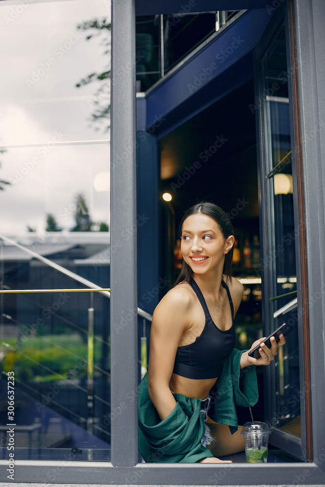 Beautiful girl in a cafe. Stylish girl in a green blouse. Lady near the window Beautiful girl in a cafe. Stylish girl in a green blouse. Lady near the window