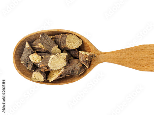 Dry Glycyrrhiza or licorice root in wooden spoon on white background photo