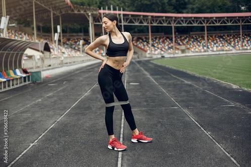 Beautiful girl at the stadium. Sports girl in a sportswear. © hetmanstock2