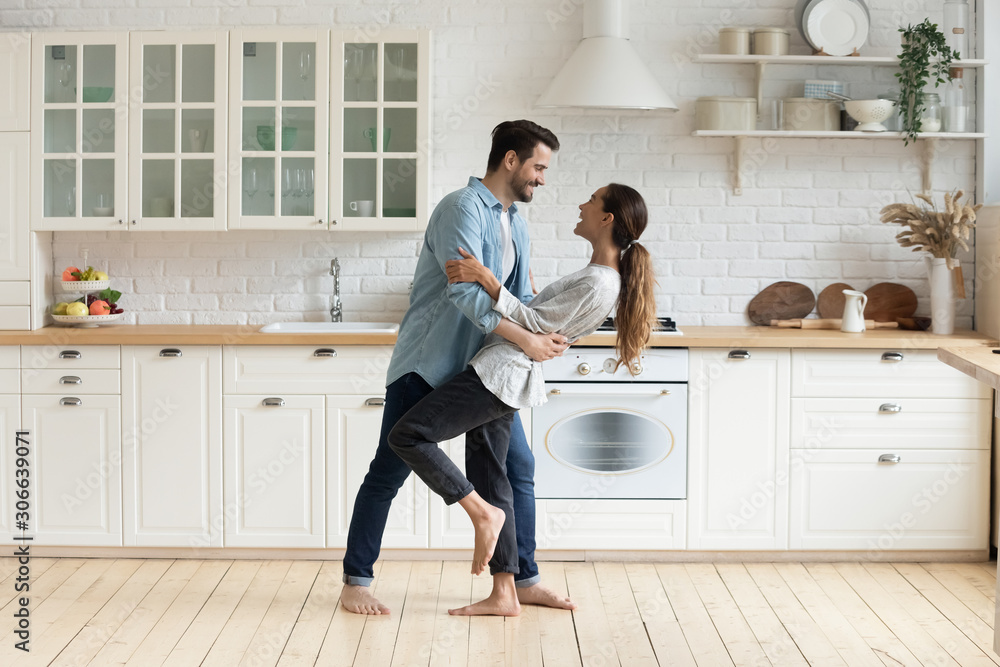 Happy romantic couple dancing in modern kitchen at home Happy romantic couple dancing in modern kitchen at home