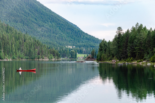 a man in a canoe on lazy lake , canada