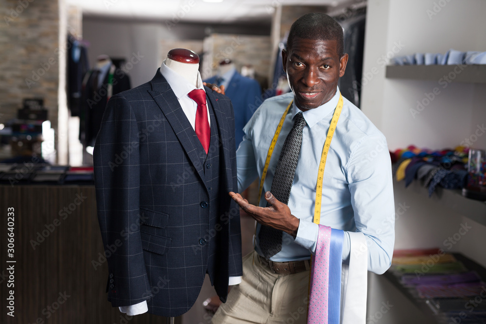 Afro-american man buyer in shirt choosing colored tie in the dress shop