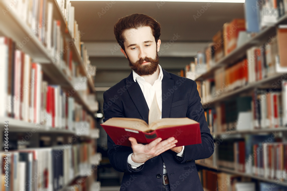 Man in a library. Guy in a black suit. Student with a books. Man in a library. Guy in a black suit. Student with a books.