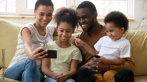 Happy african American family making selfie on smartphone together