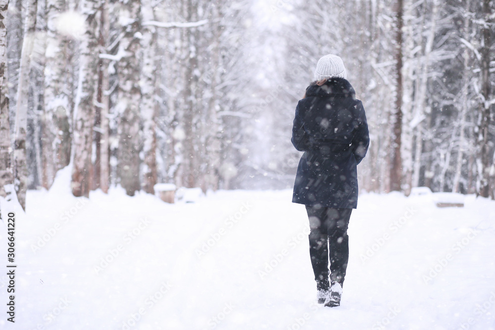 Girl in a winter park in snowfall Girl in a winter park in snowfall