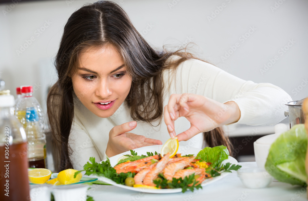 Woman decorating fried prawns .