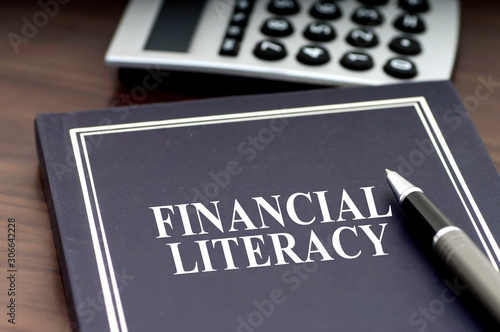 Financial Literacy book with pen and calculator