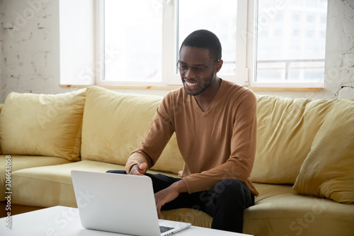 Smiling african American man having video call on laptop