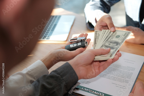 client pay for car. salesman dealer giving key to owner. car sale & dealership in auto business