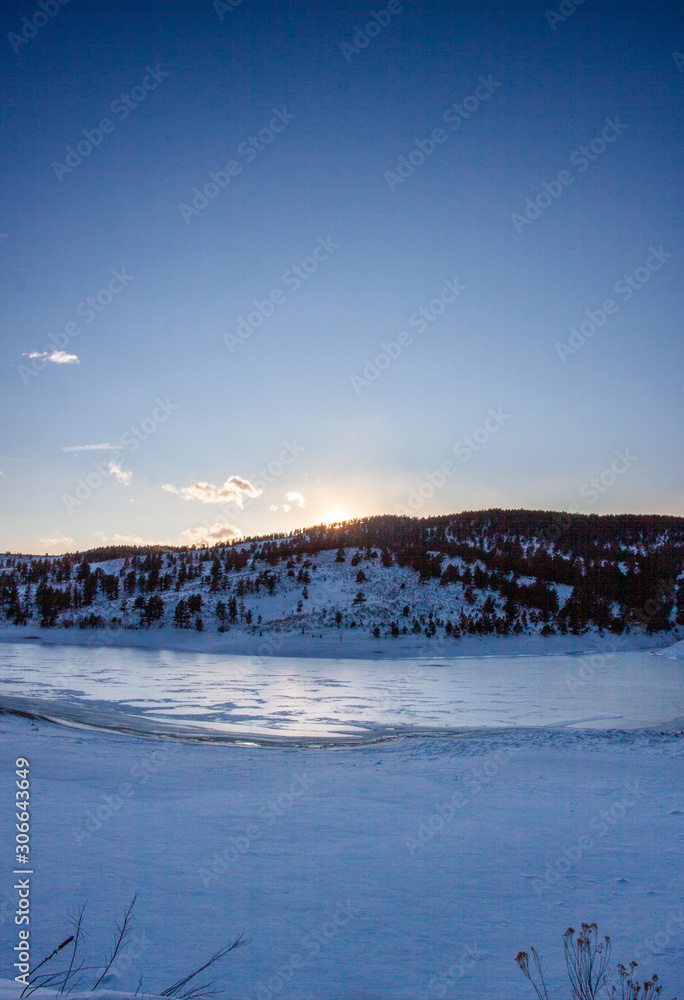 Frozen lake in the foothills of the Colorado Rockies just before sunset