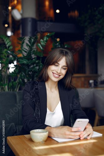 Woman working with a notebook. Lady with a coffee. Businesswoman use the phone © hetmanstock2