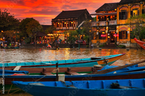 Traditional boats in front of ancient architecture in Hoi An, Vietnam.