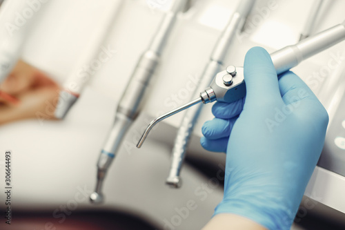 Metal instruments for the treatment of teeth. Dental clinic. Hands in a blue gloves