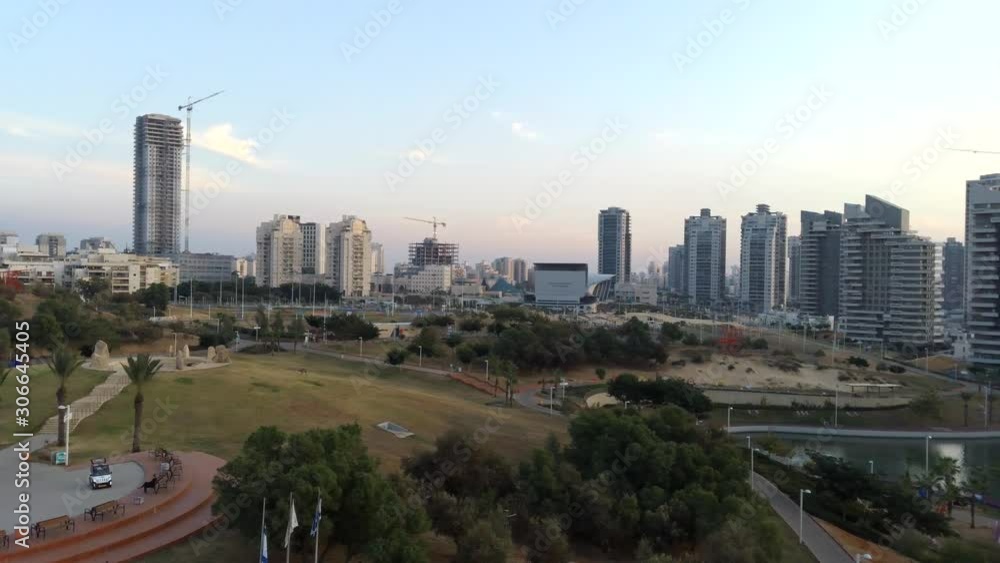Aerial flying over an Ashdod city and Ashdod-Yam Park with cloudy sunset sky, buildings, sea and coast at the background. View from above of Ashdod, Israel Aerial flying over an Ashdod city and Ashdod-Yam Park with cloudy sunset sky, buildings, sea and coast at the background. View from above of Ashdod, Israel