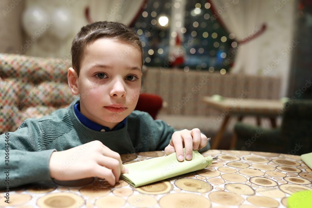 Serious child at table in restaurant Serious child at table in restaurant