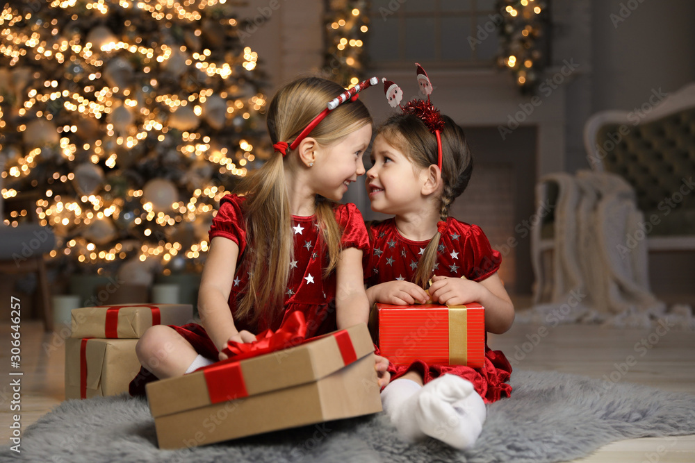 Cute little children with Christmas gifts in living room Cute little children with Christmas gifts in living room