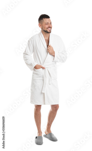 Handsome man wearing bathrobe on white background