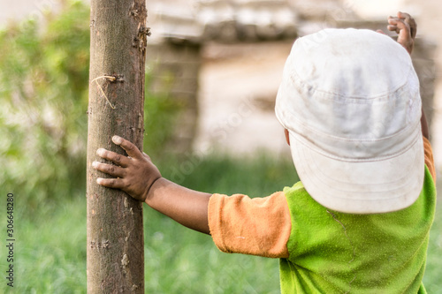 a cute smiling happy playing boy in garden his face and clothes are dirty 