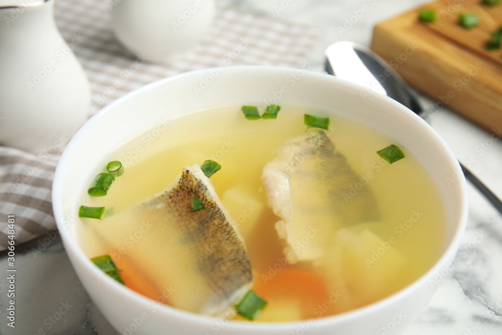 Delicious fish soup in bowl on table, closeup Delicious fish soup in bowl on table, closeup