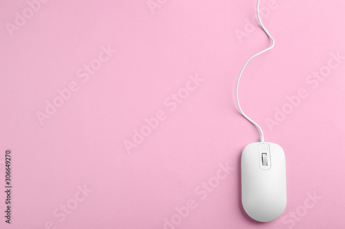 Modern wired optical mouse on pink background, top view. Space for text