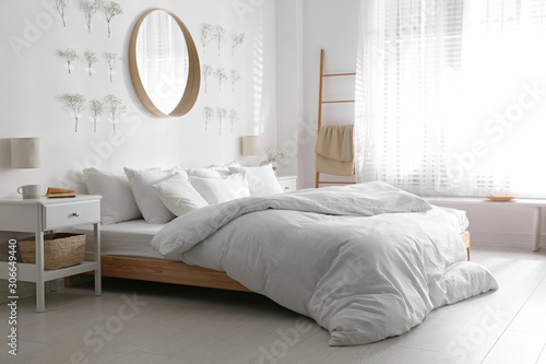 Modern bedroom interior with stylish round mirror