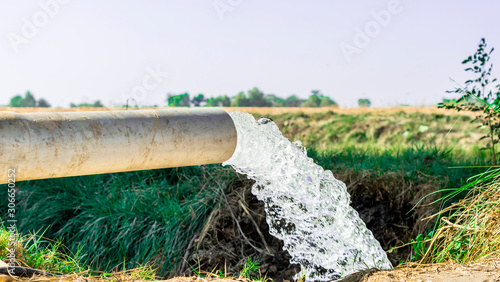 high pressure crystal bluish sweet water flushing out of an agriculture industrial tube waell in fields  