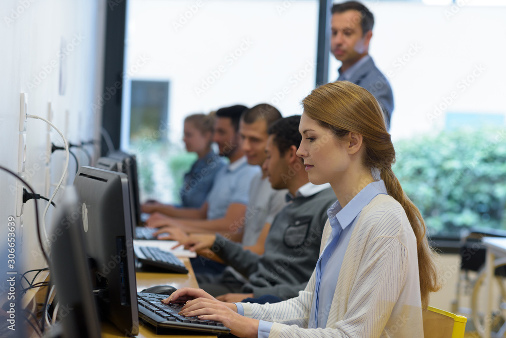 side view of attentive students e-learning in classroom