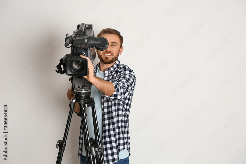 Operator with professional video camera on white background, space for text
