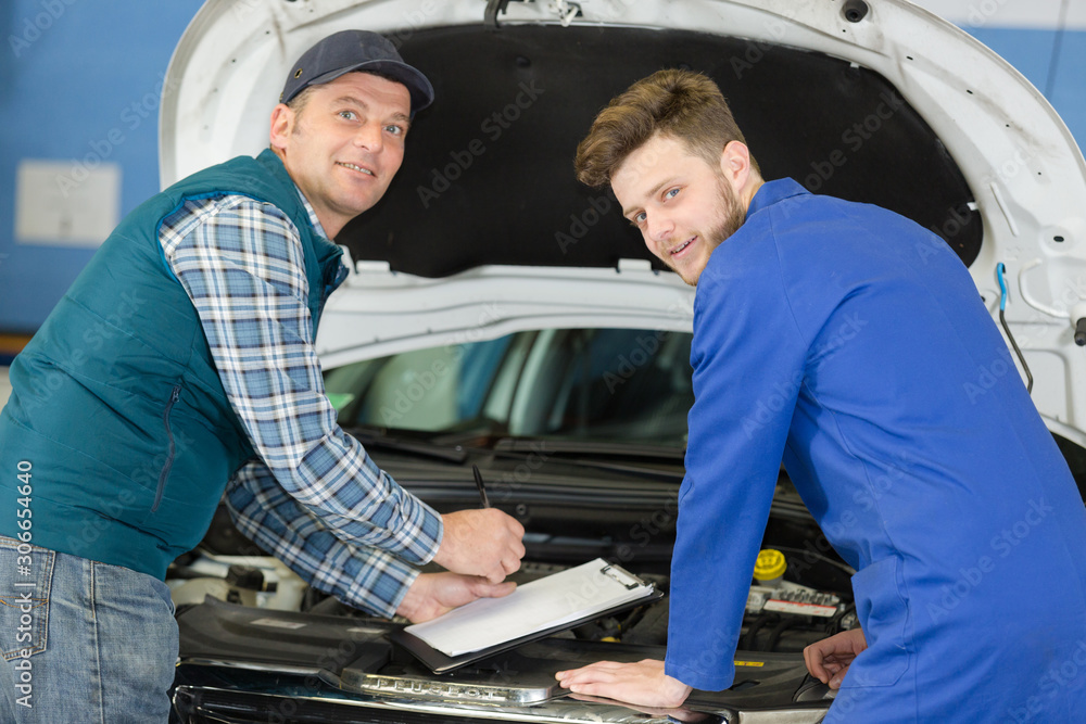 mechanic showing apprentice in doing diagnostic