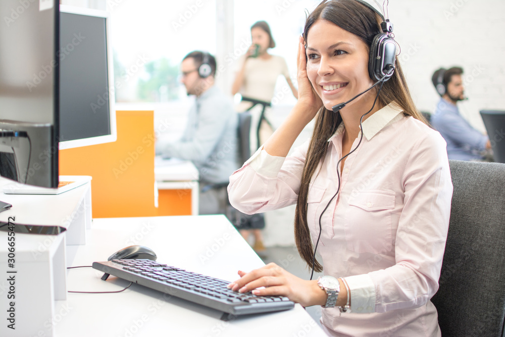Portrait of happy smiling female customer support phone operator at workplace. Portrait of happy smiling female customer support phone operator at workplace.