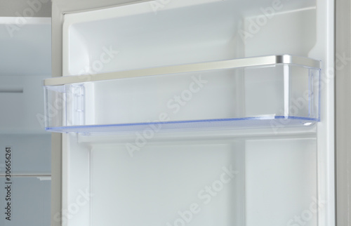 Door shelf of empty modern refrigerator, closeup view