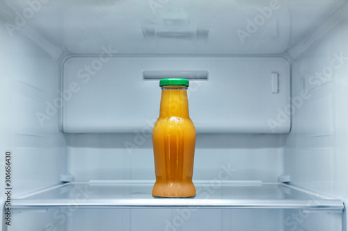 Bottle of juice on shelf in refrigerator