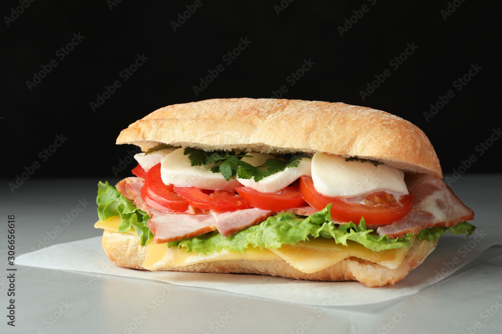 Delicious sandwich with fresh vegetables and mozzarella on grey table