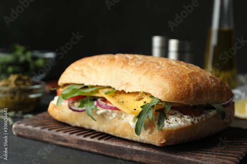 Delicious sandwich with fresh vegetables and cheese on grey table