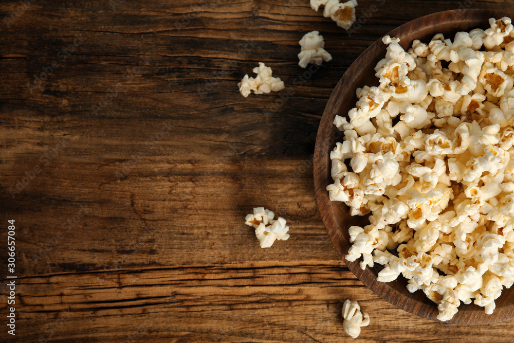 Fototapeta premium Tasty pop corn on wooden table, flat lay. Space for text