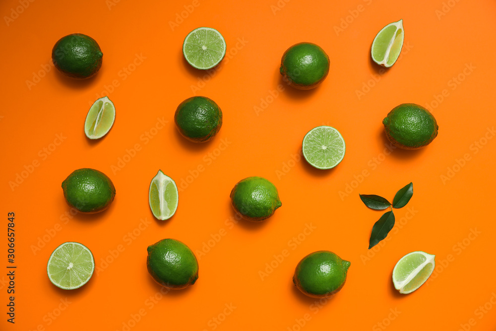 Flat lay composition with fresh juicy limes on orange background Flat lay composition with fresh juicy limes on orange background