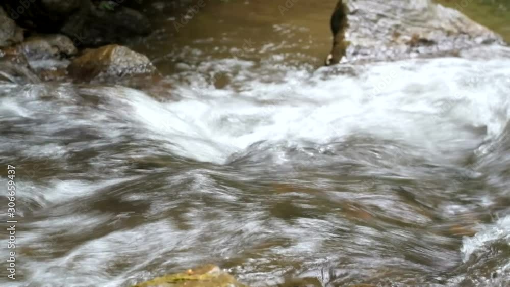 A powerful stream of water flowing among the stones. A powerful stream of water flowing among the stones.