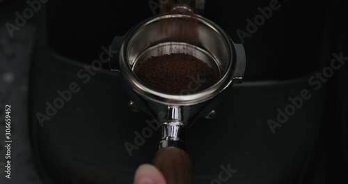 fresh ground coffee falling into portafilter from grinder