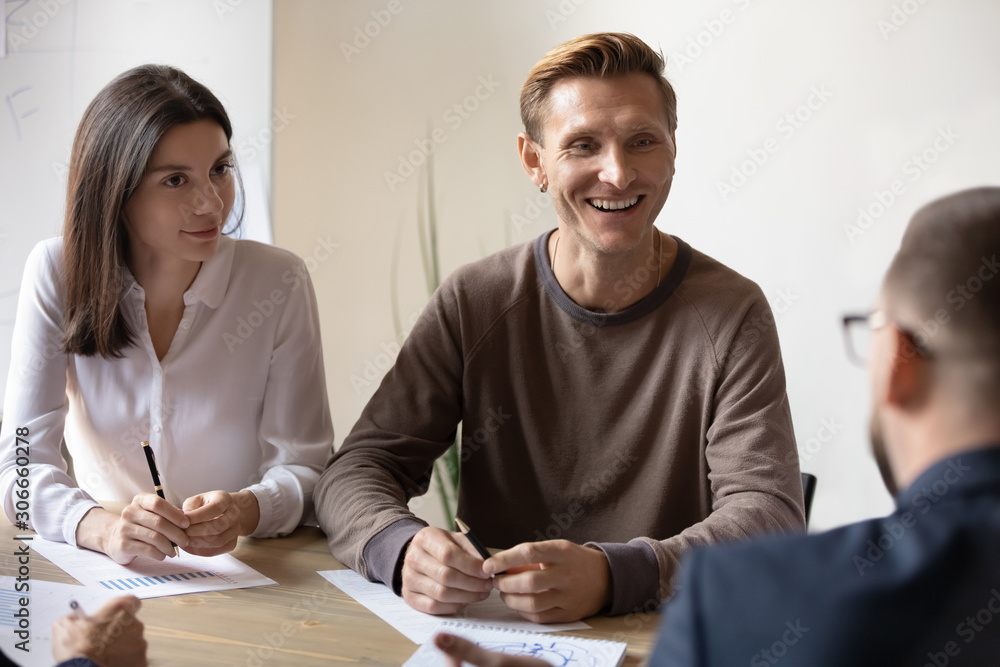 Smiling teammates discussing project with client at office. Smiling teammates discussing project with client at office.