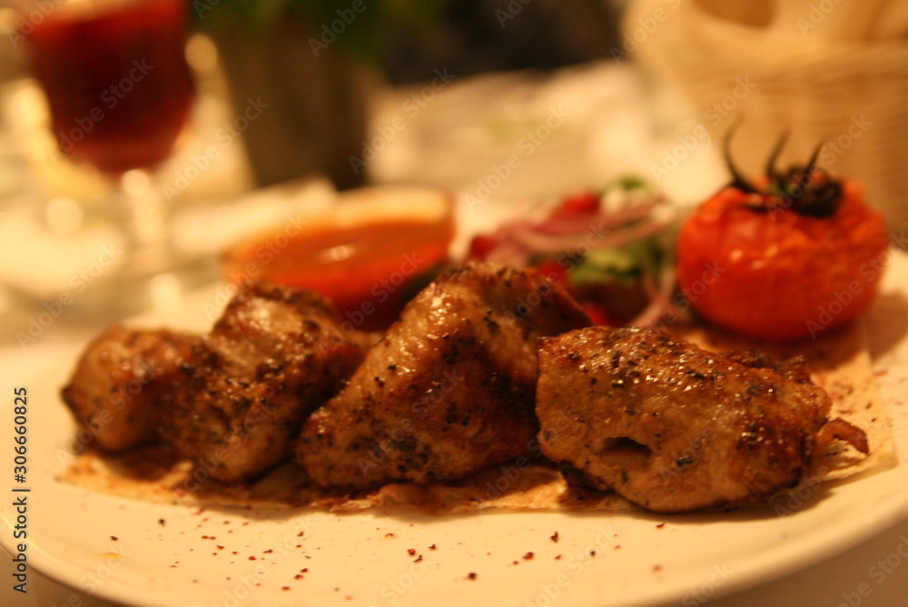 pork shish kebab with salad, sauce and tomatoes on the grill pork shish kebab with salad, sauce and tomatoes on the grill