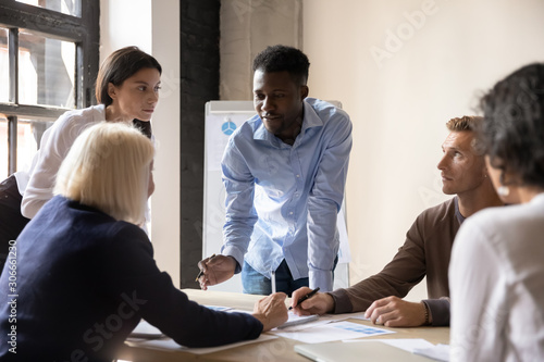 Focused diverse coworkers developing marketing strategy at office.