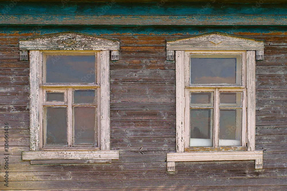 Two windows of an old rustic wooden house close-up