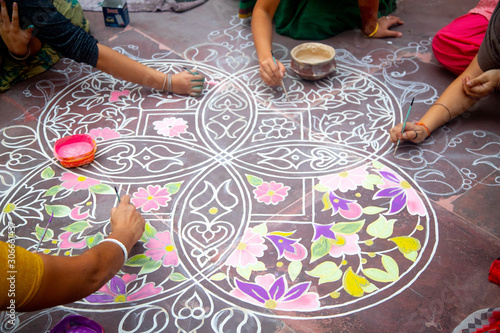 Hands of girls making rangoli - indian mandala. Indian tourism. Indian traditional culture, art and religion. decorative element. abstract Oriental background, selective focus, lifestyle