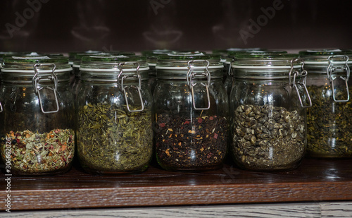 Different types of teas in glass jars on a shelf