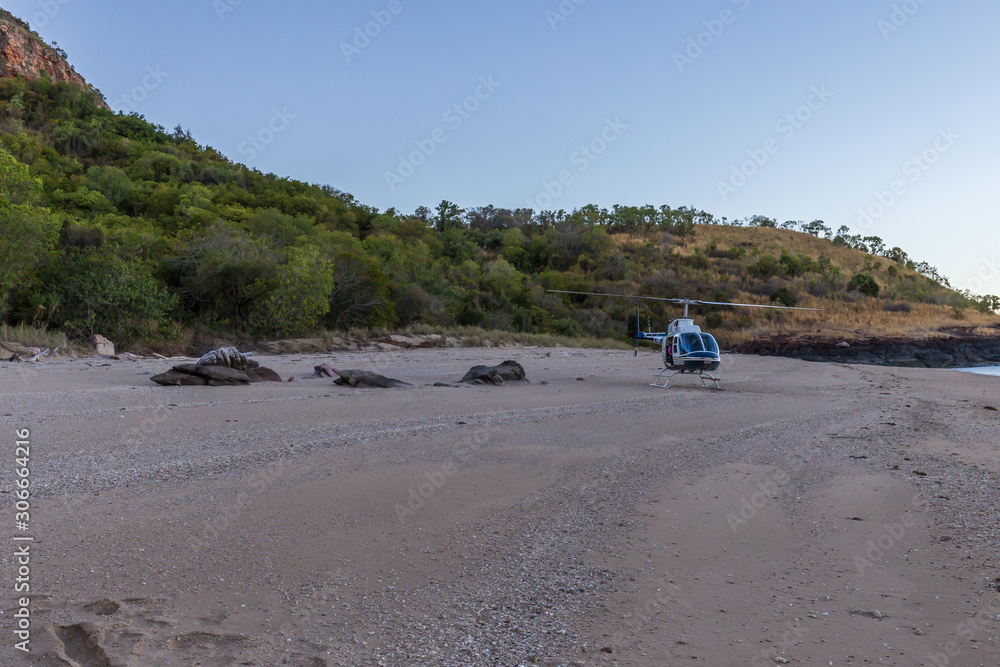 Tourists from a luxury expedition cruise ship board helicopters on a remote beach on Naturalist Island in the Kimberley for a sightseeing flight over Prince Frederick Harbour